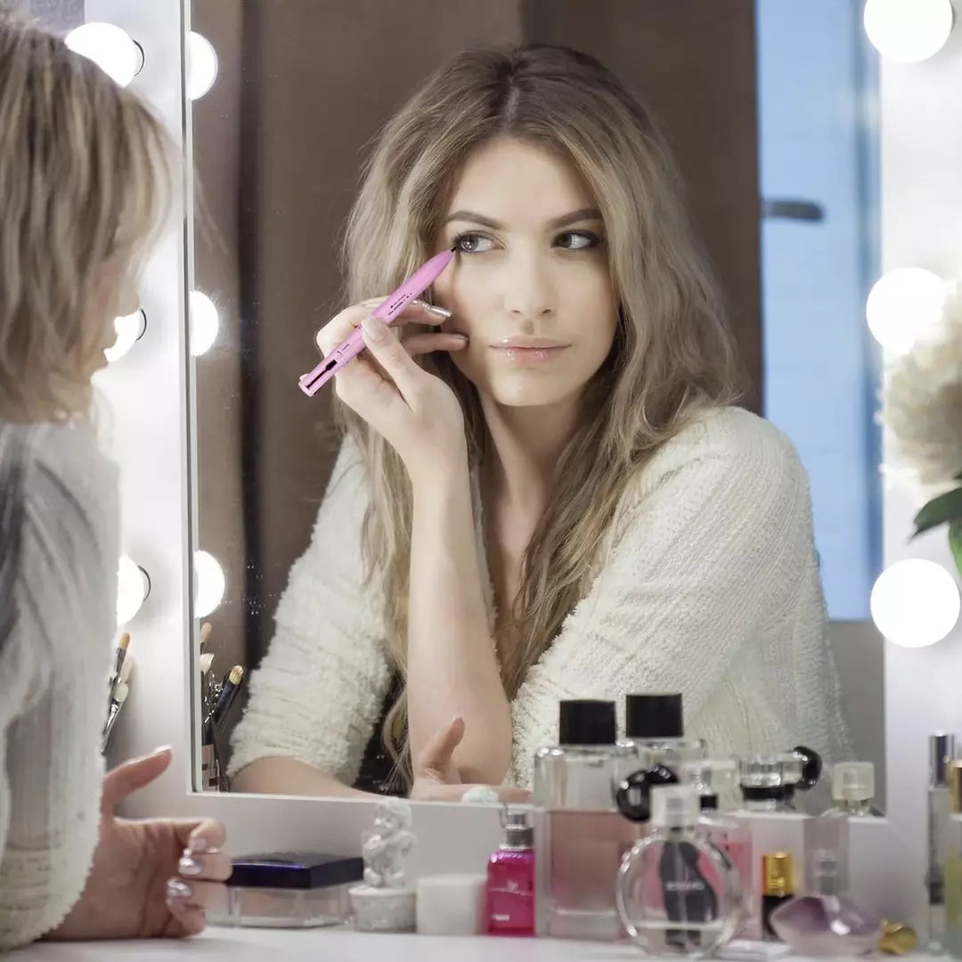 Een dame gebruikt de 4-in-1 makeup pen en kijkt in een spiegel. Ze gebruikt de eyeliner om een mooie wing te creëren. Ze kan ook de lipliner, highlighter en wenkbrauwpen nog gebruiken. 