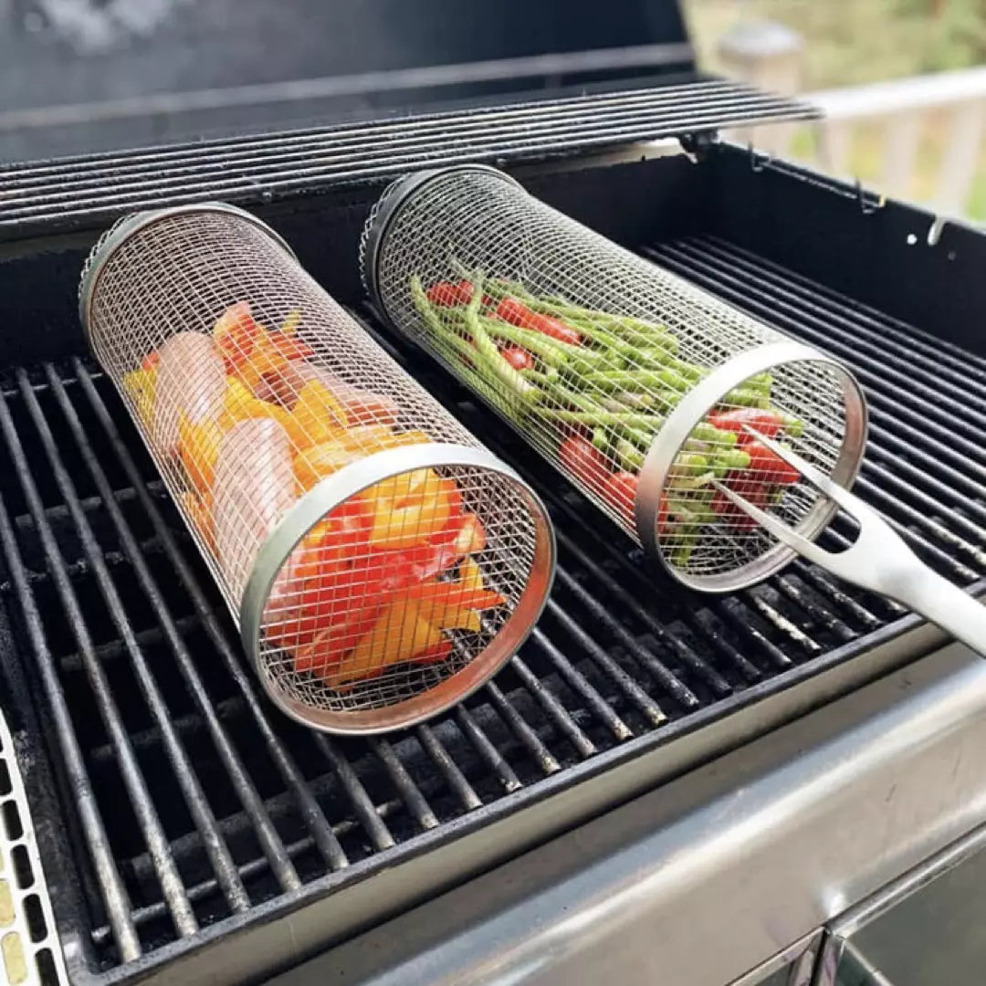 Twee BBQ Grillmanden van roestvrijstaal. De grillmanden zijn gevuld met groente en liggen op de BBQ. 