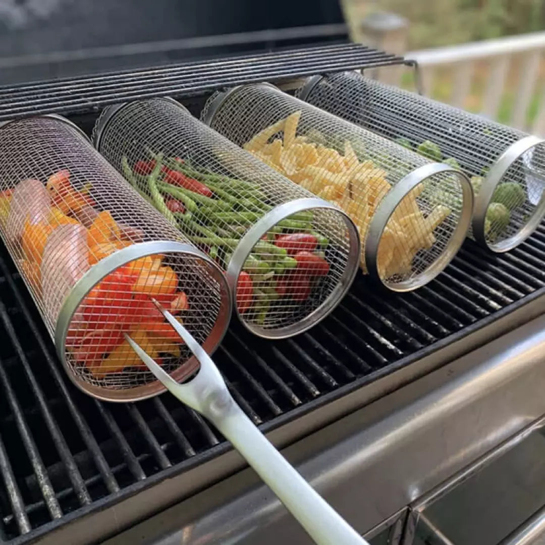 Vier BBQ Grillmanden van roestvrijstaal. De grillmanden zijn gevuld met groente en liggen op de BBQ. 