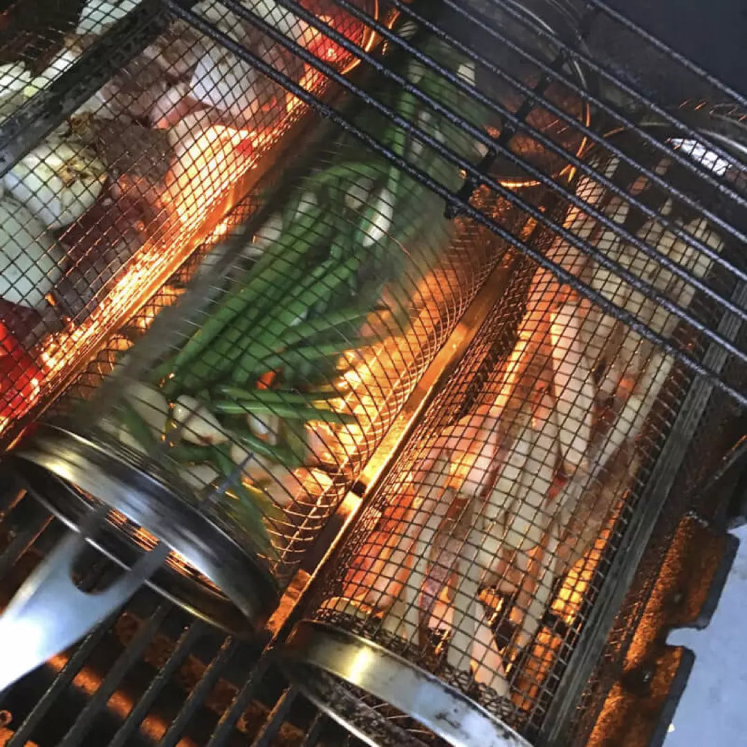 Drie BBQ Grillmanden van roestvrijstaal. De grillmanden zijn gevuld met groente en liggen op de BBQ.