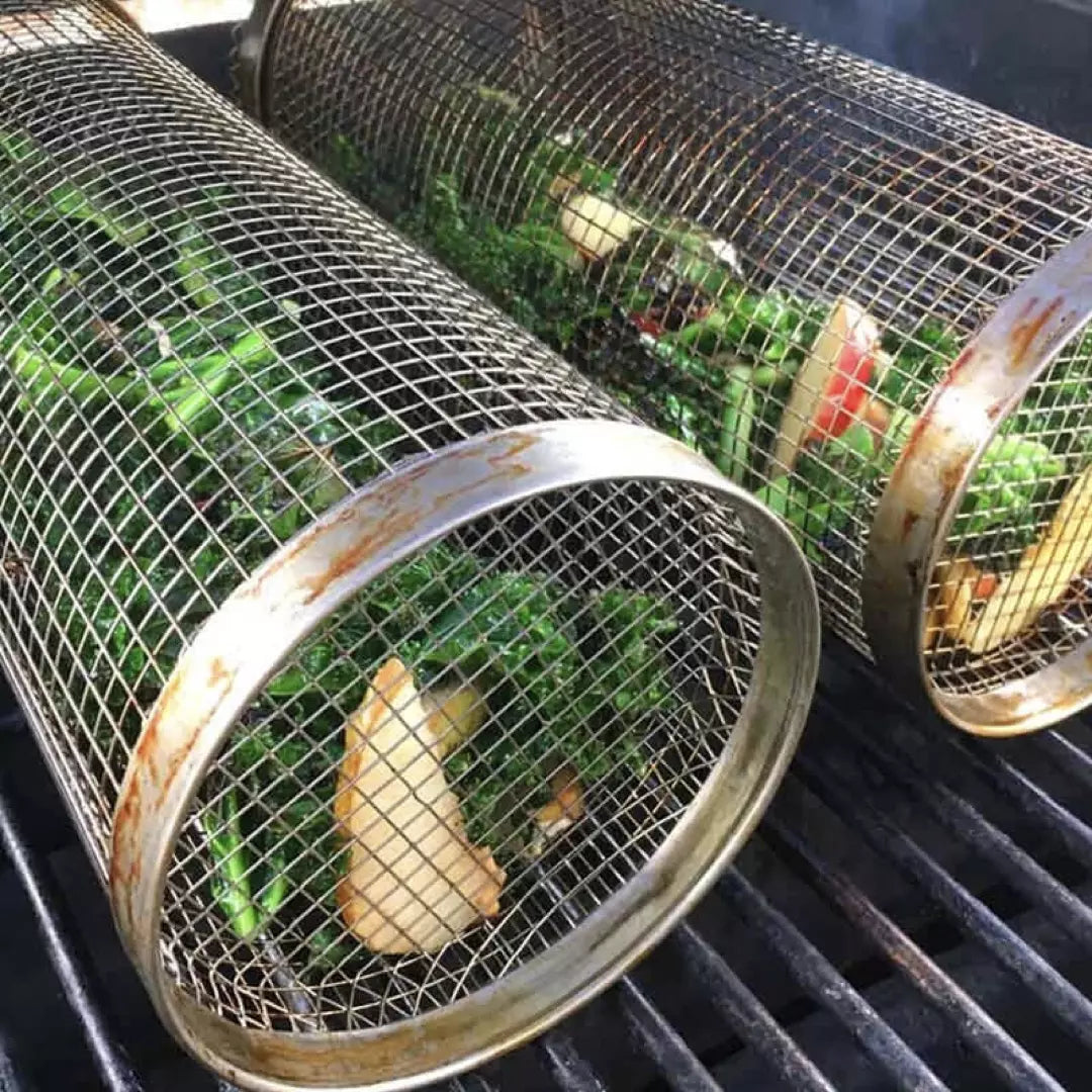 Twee BBQ Grillmanden van roestvrijstaal. De grillmanden zijn gevuld met groente en liggen op de BBQ.