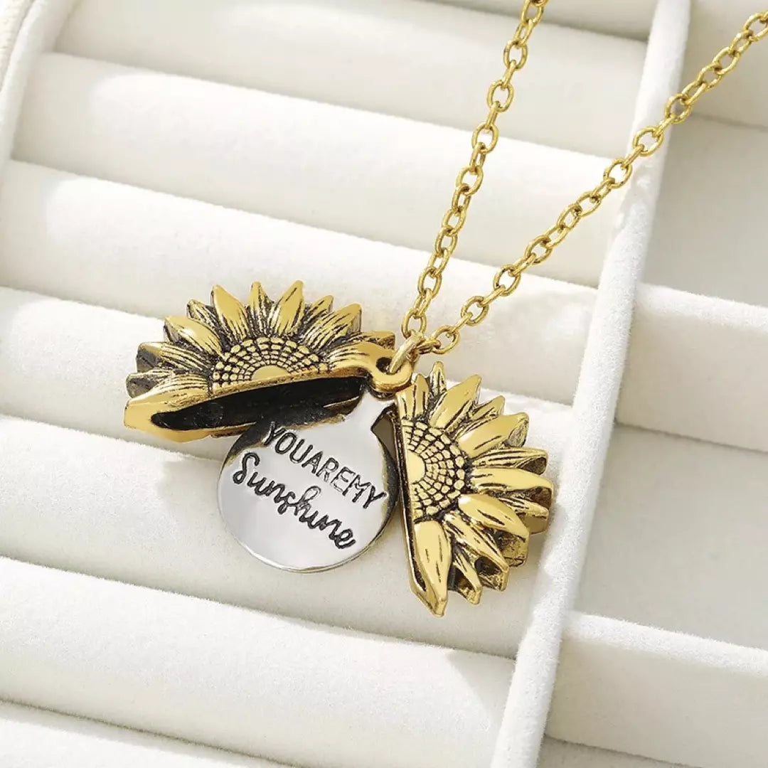 De gouden variant van de 'You are my Sunshine' ketting wordt gedragen door een model. De ketting is geopend en je ziet de mooie boodschap.