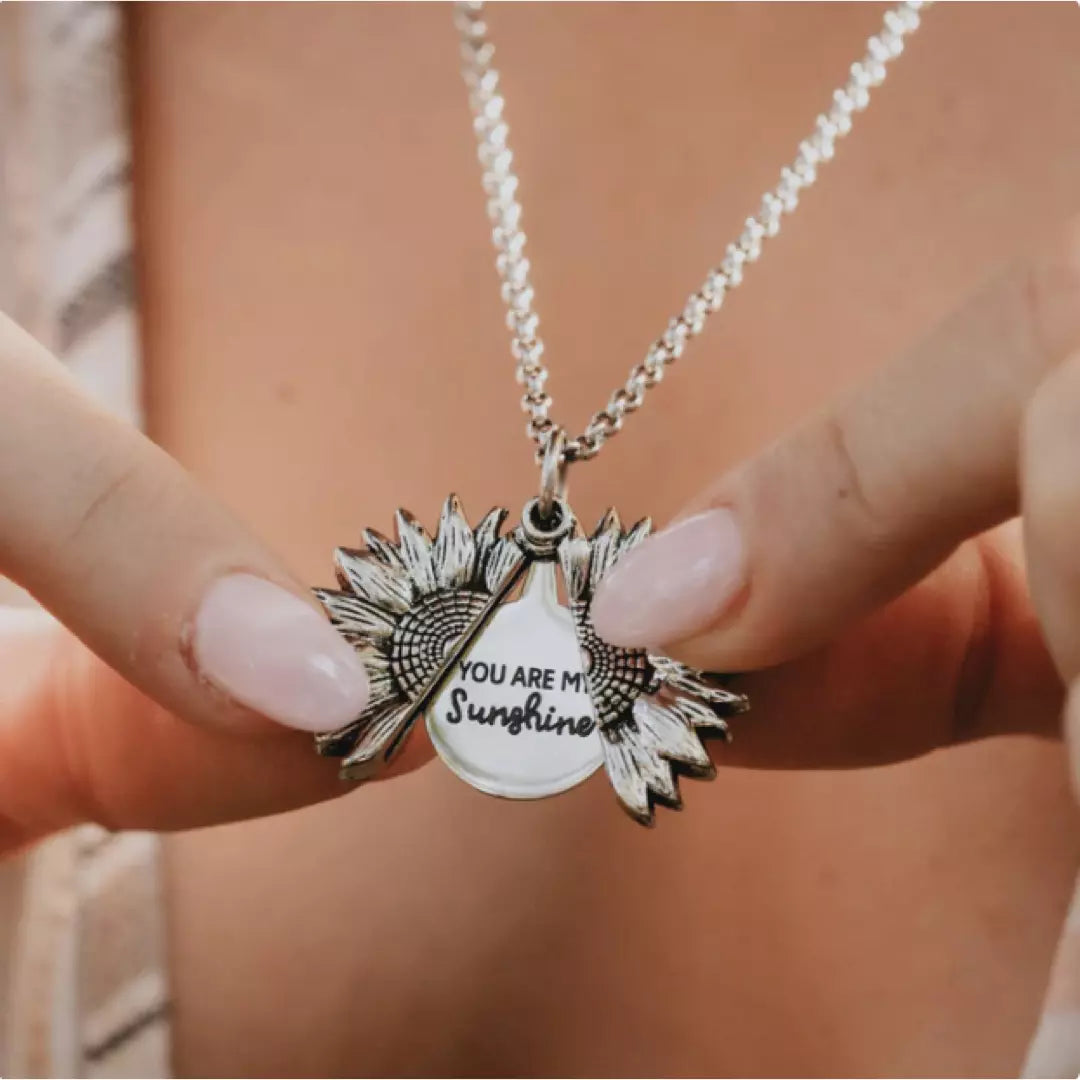 De zilveren variant van de 'You are my Sunshine' ketting wordt gedragen door een model. De ketting is geopend en je ziet de mooie boodschap.