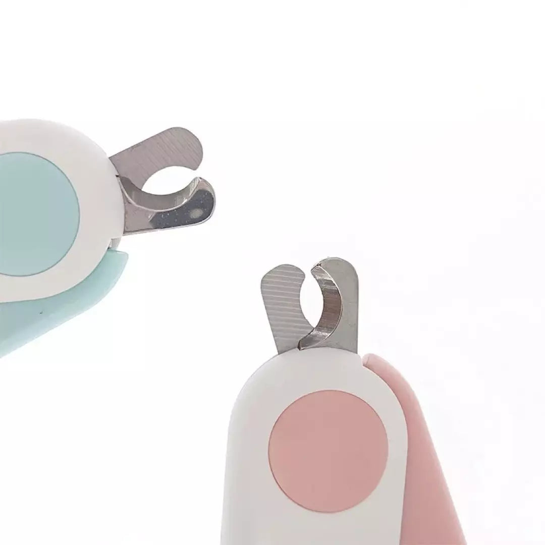 De blauwe en roze nagelknippers voor huisdieren met ingebouwd LED licht zijn te zien.