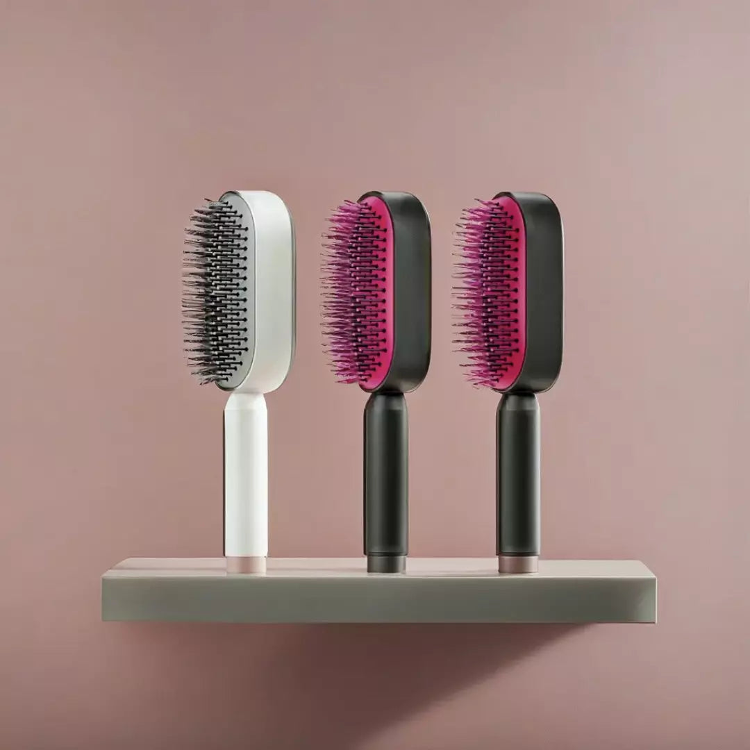 De drie varianten van de ZenTangle zelfreinigende haarborstel. De witte, rode en roze variant staan op een tafel. Je haarborstel schoonmaken kost vanaf nu geen enkele moeite meer.