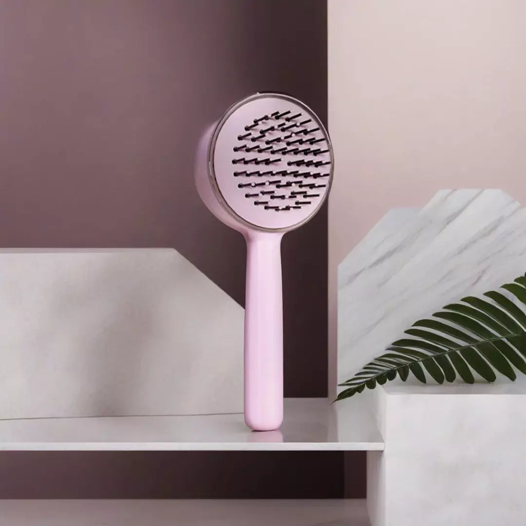 De roze ronde ZenTangle zelfreinigende haarborstel staat op een wit plateau. De voorkant van de borstel is te zien. Je haarborstel schoonmaken kost vanaf nu geen enkele moeite meer.