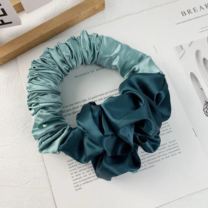 De grote scrunchie in de kleur turquoise. De zijden scrunchie is perfect voor heatless curls. Beste resultaten tijdens het slapen.